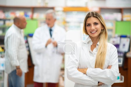 Foto de Retrato de un joven farmacéutico sonriente en una farmacia - Imagen libre de derechos