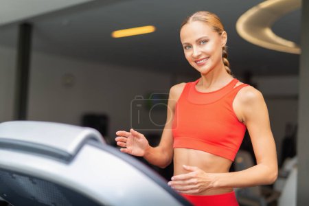 Téléchargez les photos : Femme courant dans une salle de gym, séance d'entraînement cardio - en image libre de droit