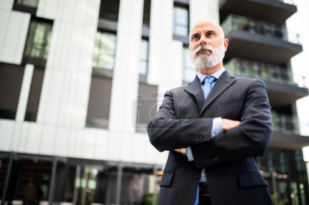 Photo for Mature bald stylish businessman portrait with a white beard outdoor with folded arms - Royalty Free Image