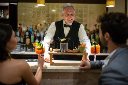 Téléchargez les photos : Bar servant des cocktails à un couple au comptoir du bar - en image libre de droit