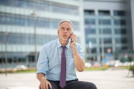 Photo for Angry senior businessman yelling at the phone outdoor - Royalty Free Image