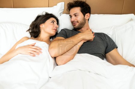 Téléchargez les photos : Jeune couple se regardant profondément sous les couvertures - en image libre de droit
