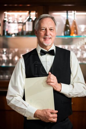 Téléchargez les photos : Portrait d'un maître aîné dans un élégant restaurant contenant quelques menus - en image libre de droit