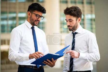 Photo for Business people reading a document together - Royalty Free Image