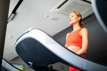 Photo for Young athletic beautiful woman training on a treadmill in the gym - Royalty Free Image