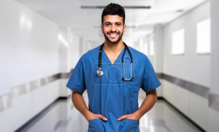 Téléchargez les photos : Homme infirmier souriant en toute confiance dans une clinique - en image libre de droit