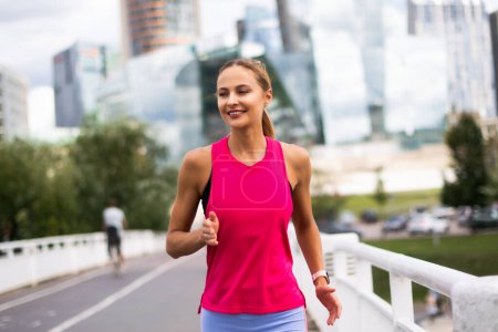 Photo for Woman running outdoor on a bridge in a modern city - Royalty Free Image