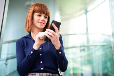 Téléchargez les photos : Jeune femme d'affaires utilisant son smartphone - en image libre de droit