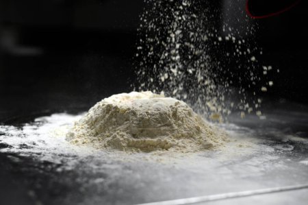 Photo for Flour pours on fresh homemade dough - Royalty Free Image