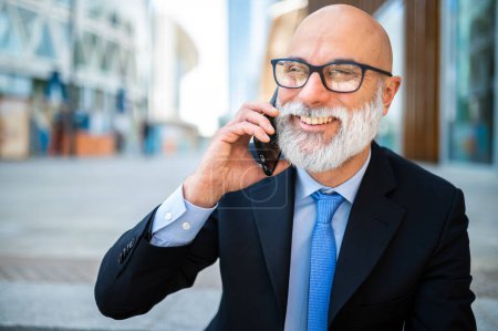 Photo for Stylish senior manager on the phone looking happy - Royalty Free Image