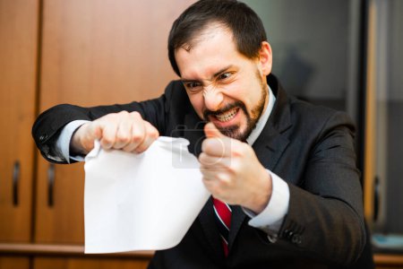 Téléchargez les photos : Homme d'affaires en colère déchirant un document - en image libre de droit