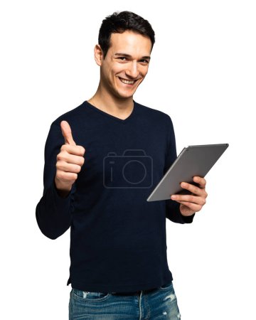 Photo for Cheerful young adult male holding a digital tablet and showing approval with a thumbs up gesture - Royalty Free Image