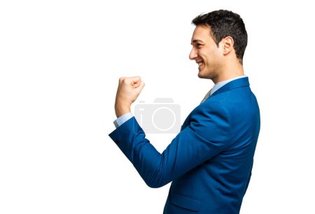 Foto de Perfil lateral de un alegre hombre de negocios en un traje azul haciendo un gesto de victoria con un fondo blanco - Imagen libre de derechos