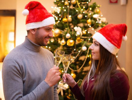 Foto de Un par de copas de champán tostadas en casa juntas durante la víspera de Navidad - Imagen libre de derechos