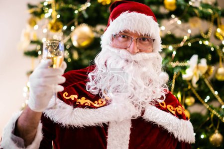 Photo for Photo of happy Santa Claus in eyeglasses holding a glass of champagne - Royalty Free Image