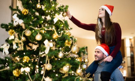 Photo for Happy couple decorating a christmas tree together - Royalty Free Image