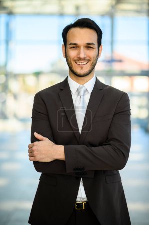 Foto de Retrato de un joven sonriente en un traje de pie con confianza al aire libre - Imagen libre de derechos