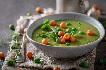 Homemade pea soup made of vegetables and herbs. Green vegan soup made of vegetables.