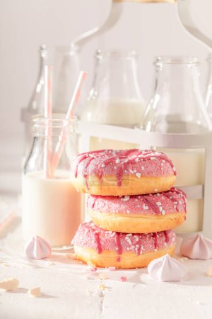 Yummy and homemade pink donuts as takeaway dessert. Served with milk. Most popular dessert.
