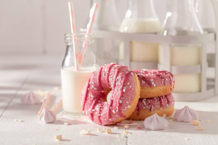 Fresh and tasty pink donuts with sprinkles and glaze. Best tastes with milk. Most popular dessert.
