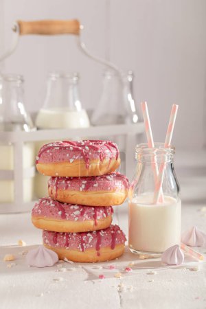 Süße und köstliche rosa Donuts, serviert mit Milch in der Flasche. Serviert mit Milch. Beliebtestes Dessert.