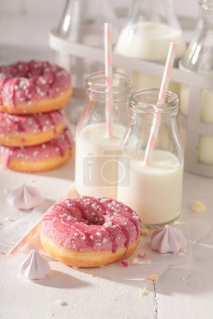 Sweet and delicious pink donuts as takeaway dessert. Served with milk. Most popular dessert.