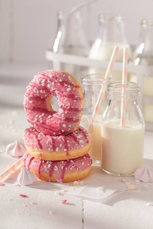 Yummy and homemade pink donuts with sprinkles and glaze. Best tastes with milk. Most popular dessert.