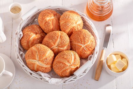Tasty Kaiser rouleaux avec des graines de sésame pour le petit déjeuner. Petit déjeuner avec petits pains, beurre et miel.