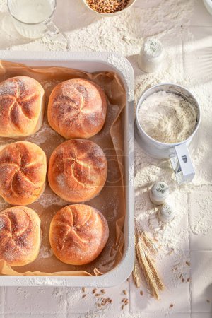 Hot and golden kaiser buns in rustic bakehouse. Kaiser buns baked in a bakery.