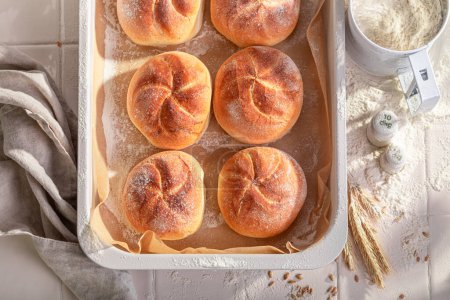 Tasty and homemade kaiser buns in rustic bakehouse. Kaiser rolls  and ingredients in the bakery.