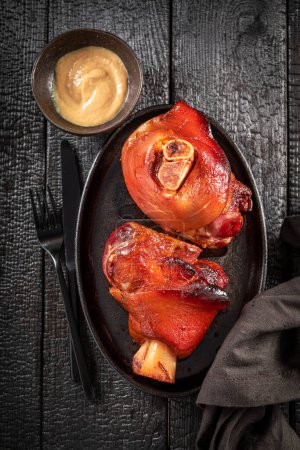 Tasty and hot Schweinshaxe baked with spices in casserole. Roasted pork knuckle with spices.