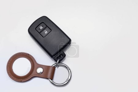 Photo for Bangkok, Thailand - April 14, 2023: Modern black remote control of car and Apple Air Tag with brown leather keychain  isolated on white background with free space for adding some text on the right - Royalty Free Image