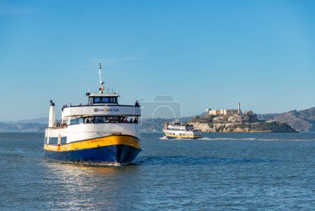 Téléchargez les photos : Une photo de deux bateaux de croisière Blue et Gold dans la baie de San Francisco, avec l'île Alcatraz à l'extrême droite. - en image libre de droit