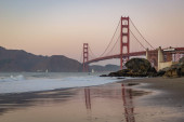 A picture of the Golden Gate Bridge and Baker Beach at sunset. Poster #653750604