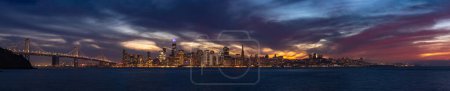 Photo for A panorama picture of the Oakland Bay Bridge and Downtown San Francisco as seen from Treasure Island at sunset. - Royalty Free Image