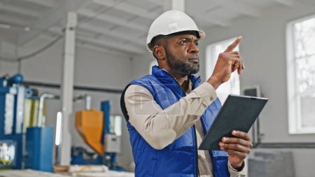Photo for Close-up of tall good-looking bearded African-American male measuring comparing and looking in his gadget. Serious worker moving his head counting and distributing updated information. - Royalty Free Image