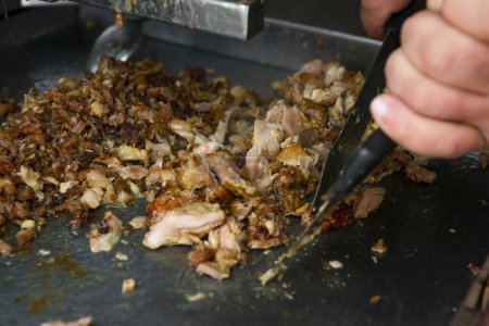Téléchargez les photos : Man cutting prepared meat for Shawarma - en image libre de droit