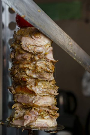 Téléchargez les photos : Man cutting prepared meat for Shawarma - en image libre de droit