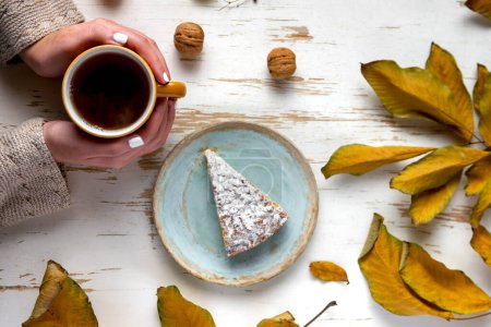 Téléchargez les photos : Tarte au four servie avec du thé chaud sur la table avec des feuilles séchées et des noix - en image libre de droit