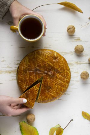 Photo for Homemade baked pie served on a shabby table with a cup of tea with autumn leaves and walnuts , autumn composition - Royalty Free Image