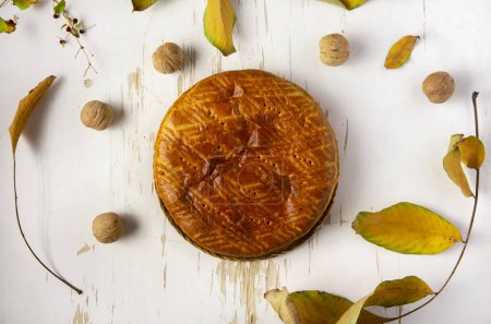 Téléchargez les photos : Tarte maison cuite au four servie sur une table minable avec des feuilles d'automne et des noix. - en image libre de droit
