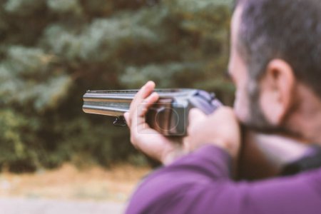 Téléchargez les photos : Homme chasseur prêt à chasser avec un fusil de chasse.chasseur tient un fusil. - en image libre de droit