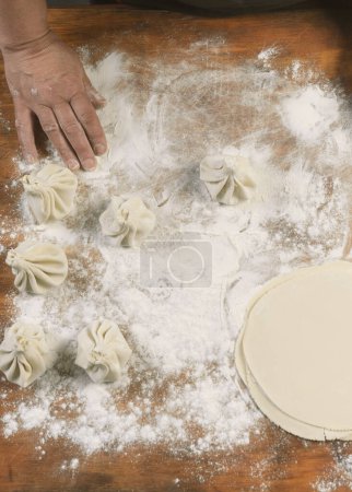 Téléchargez les photos : Chef cuisinier faire khinkali sur une table en bois. Préparation du processus repas géorgien. concept alimentaire. - en image libre de droit