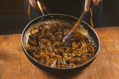 Téléchargez les photos : Chef cuisine chinois dans une casserole, en remuant avec une cuillère en bois - en image libre de droit