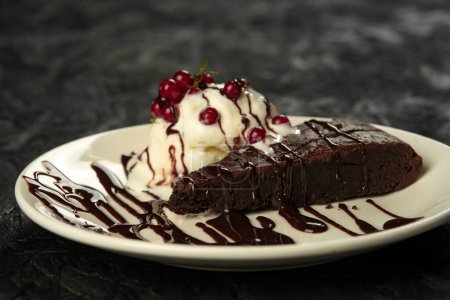 Photo for Chocolate brownie with ice cream and berries on a black background - Royalty Free Image