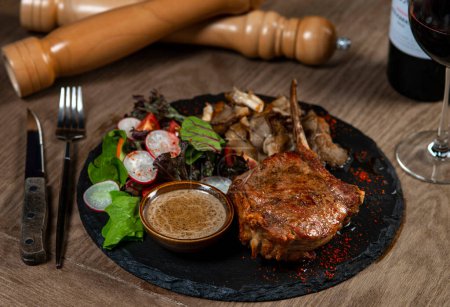 Téléchargez les photos : Steak de porc avec sauce et salade sur table en bois, gros plan - en image libre de droit