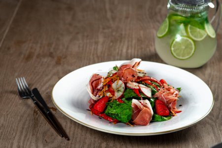 Photo for Salad with ham, spinach and mozzarella on wooden table - Royalty Free Image