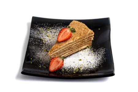 Téléchargez les photos : Couche de gâteau éponge aux fraises sur une plaque noire isolée sur fond blanc - en image libre de droit