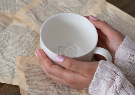 Photo for Female hands with pink manicure holding an empty white cup - Royalty Free Image