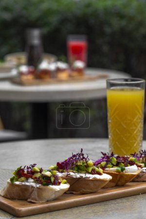 Foto de Canapés con aguacate, queso mozzarella y salsa sobre tabla de madera. bruschetta - Imagen libre de derechos